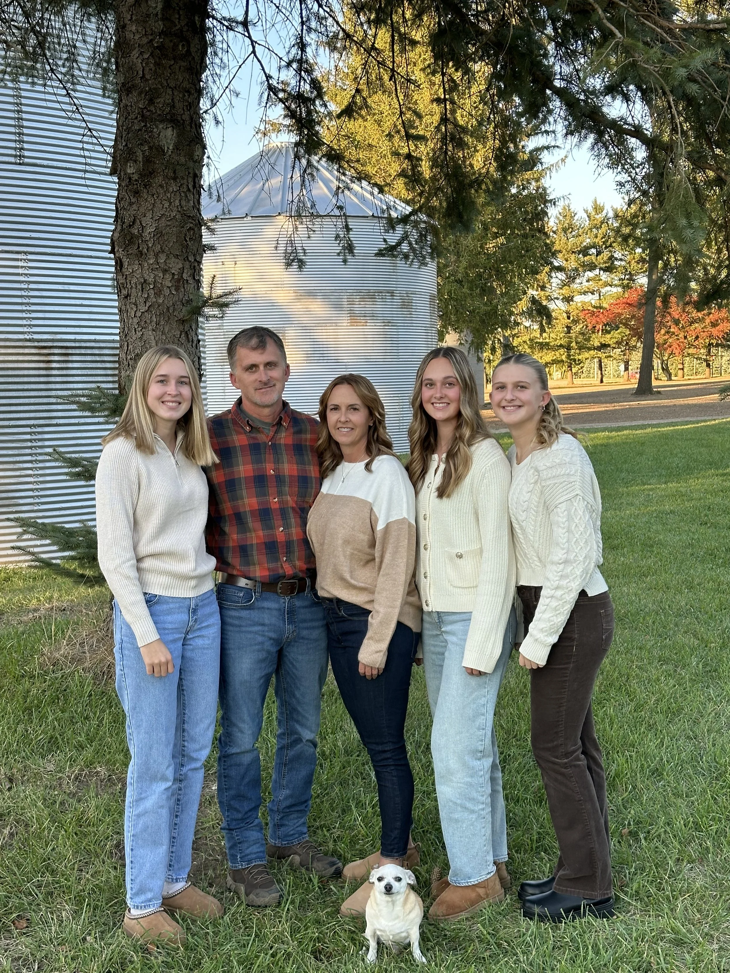 Walt, Rachel, and their daughters Ella, Karin, and Taylor with the family dog in front of a grain bin.