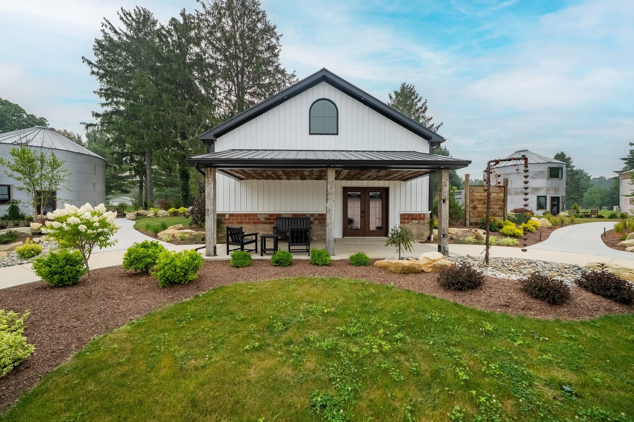 The white packing-house barn at The Farm 1893 — covered porch, grain bins, and gardens on the Berlin Heights land.