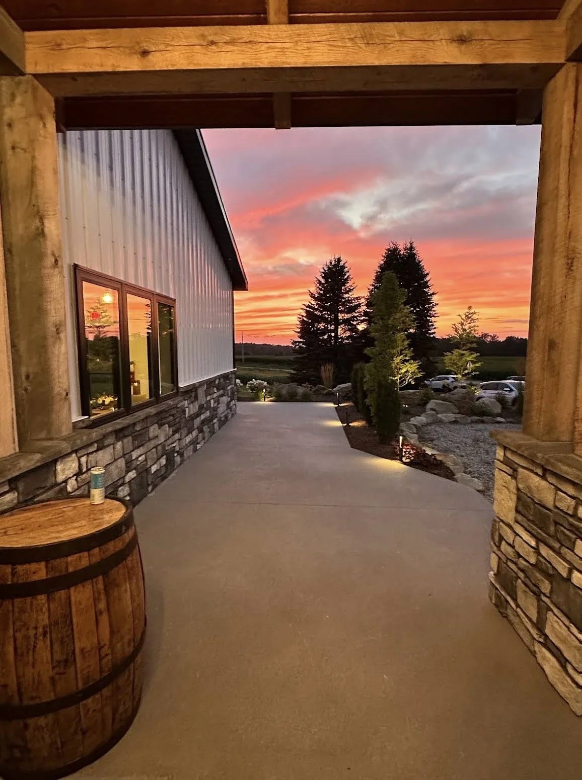 Covered porch at The Farm 1893 looking out to a pink and orange Ohio sunset over the fields.